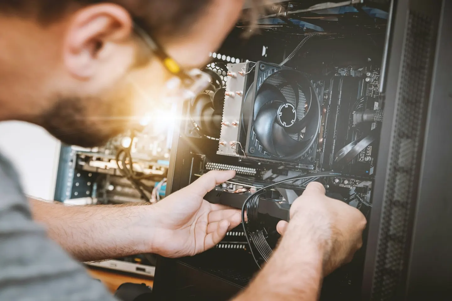 Hands working inside an open desktop computer