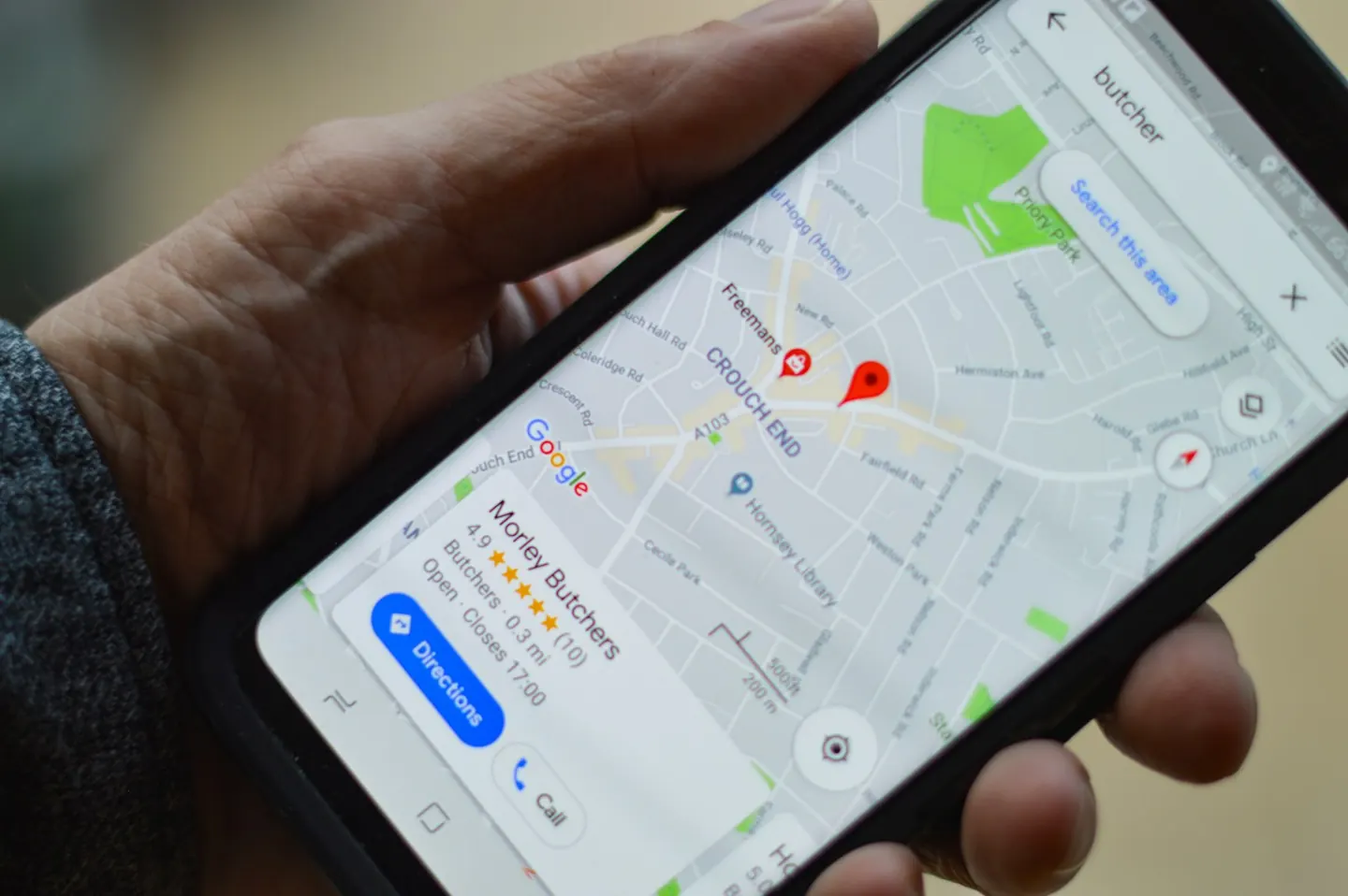 A hand holding a phone with Google Maps open