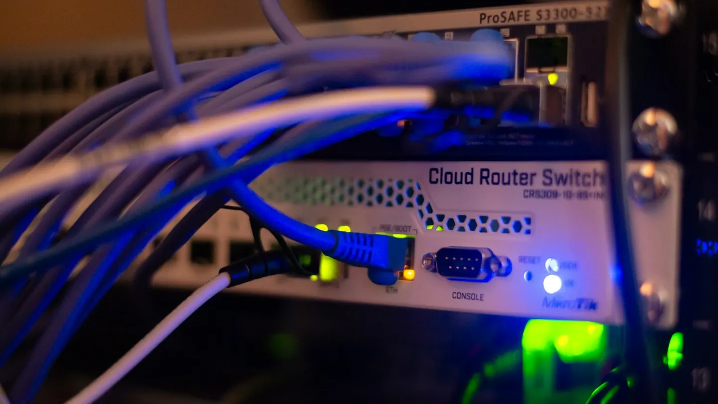 Blue network cables plugged into a router and switch