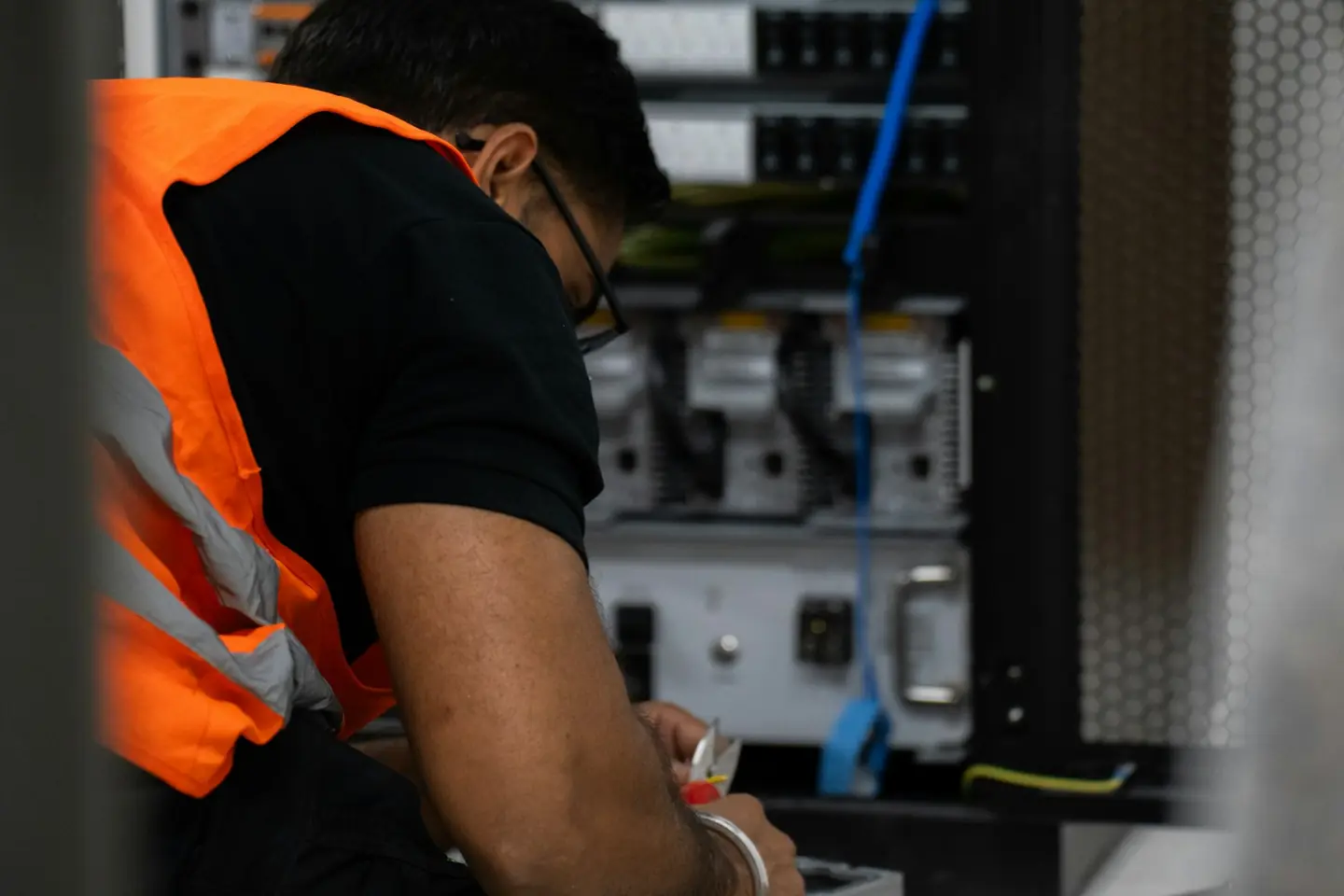 A technician working on equipment in a server rack