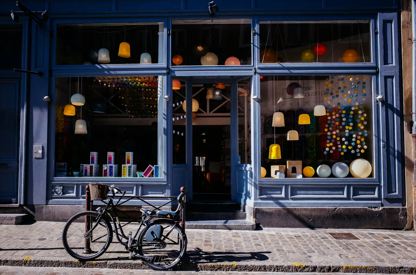 A small shop front with a bicycle parked by the window