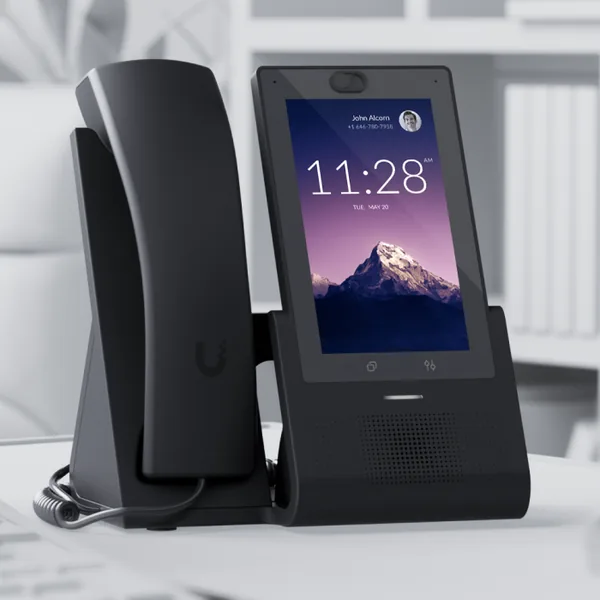 A UniFi Talk touchscreen desk phone on an office desk